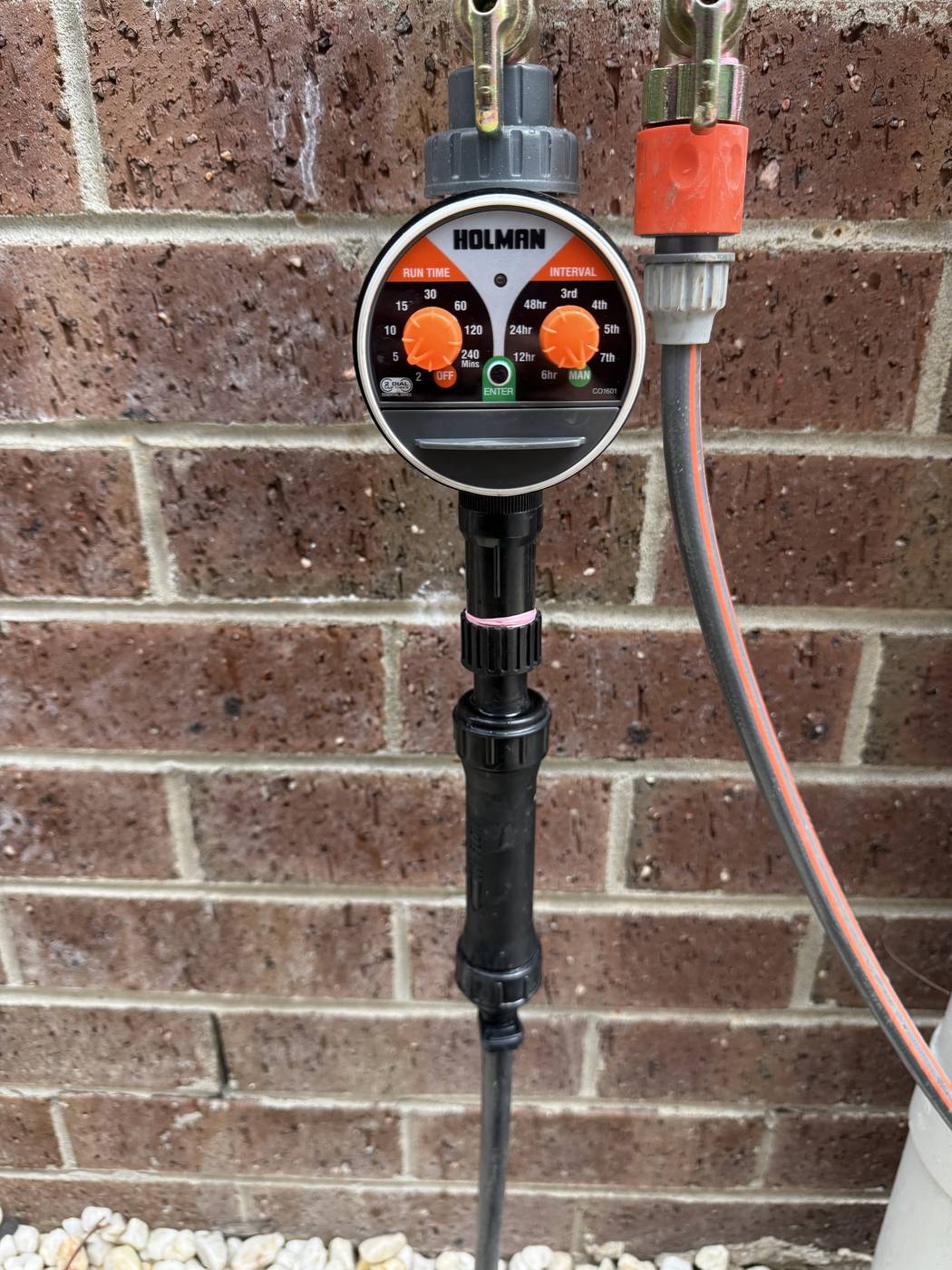 A neat tap-timer and drip-line install against a brick wall