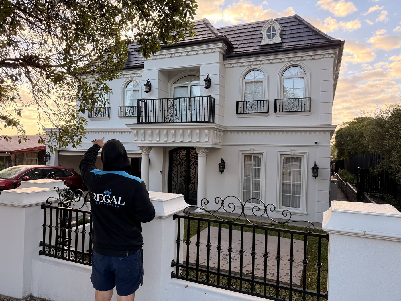 Mid-install at a grand white home frontage, golden hour