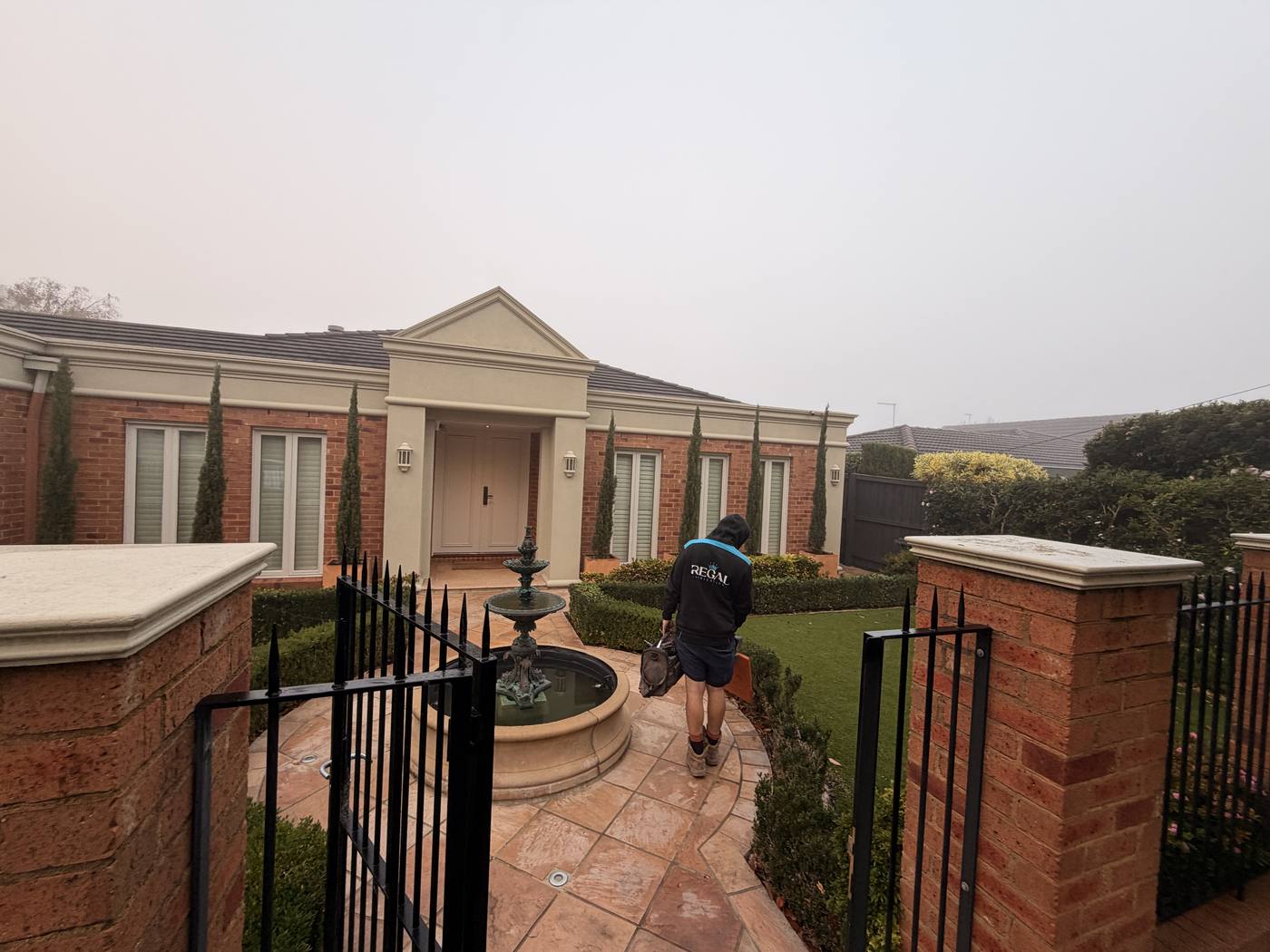 A premium brick-pillar gated entry with manicured garden