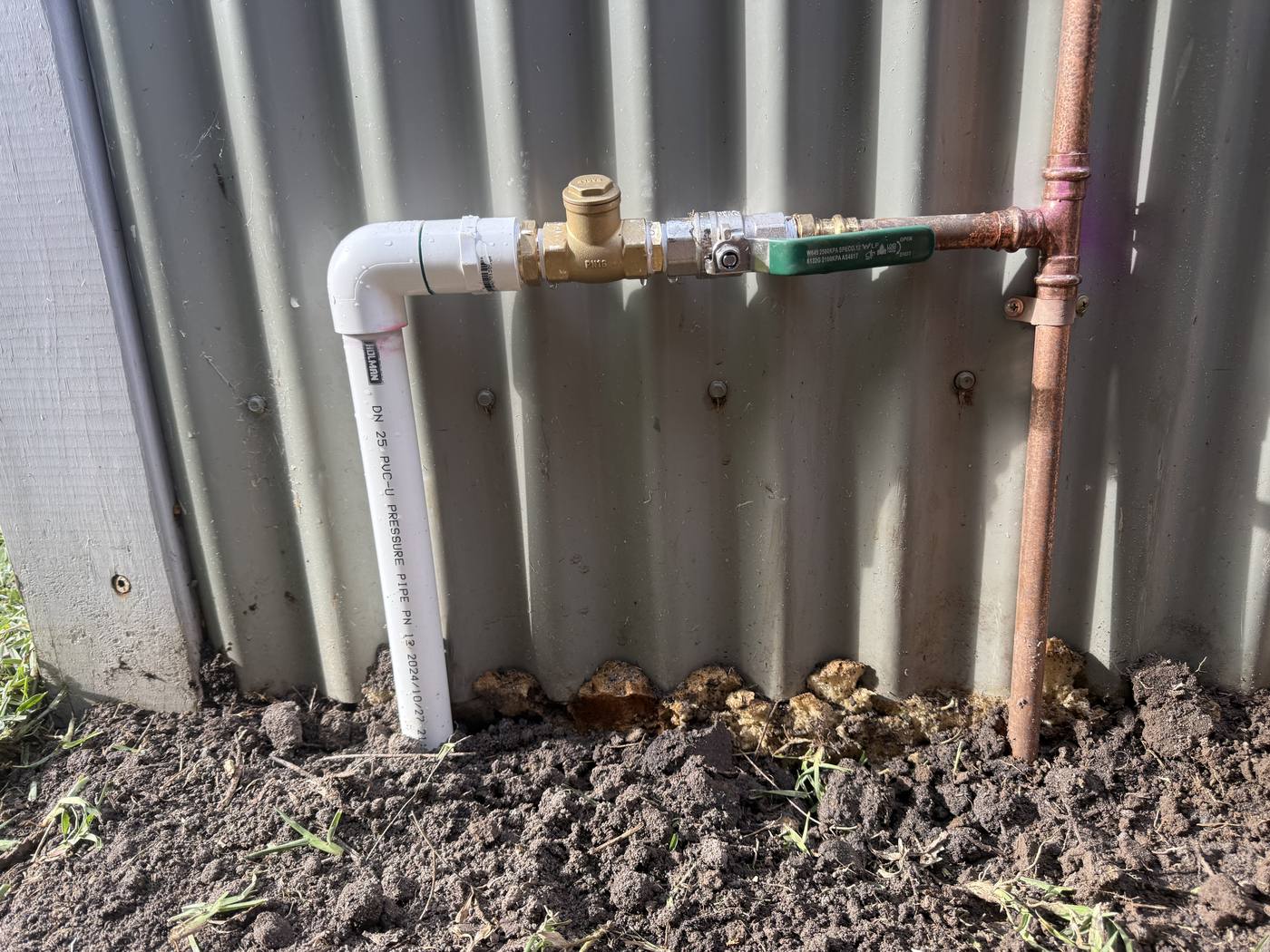 A tidy copper-and-PVC manifold with isolation valves