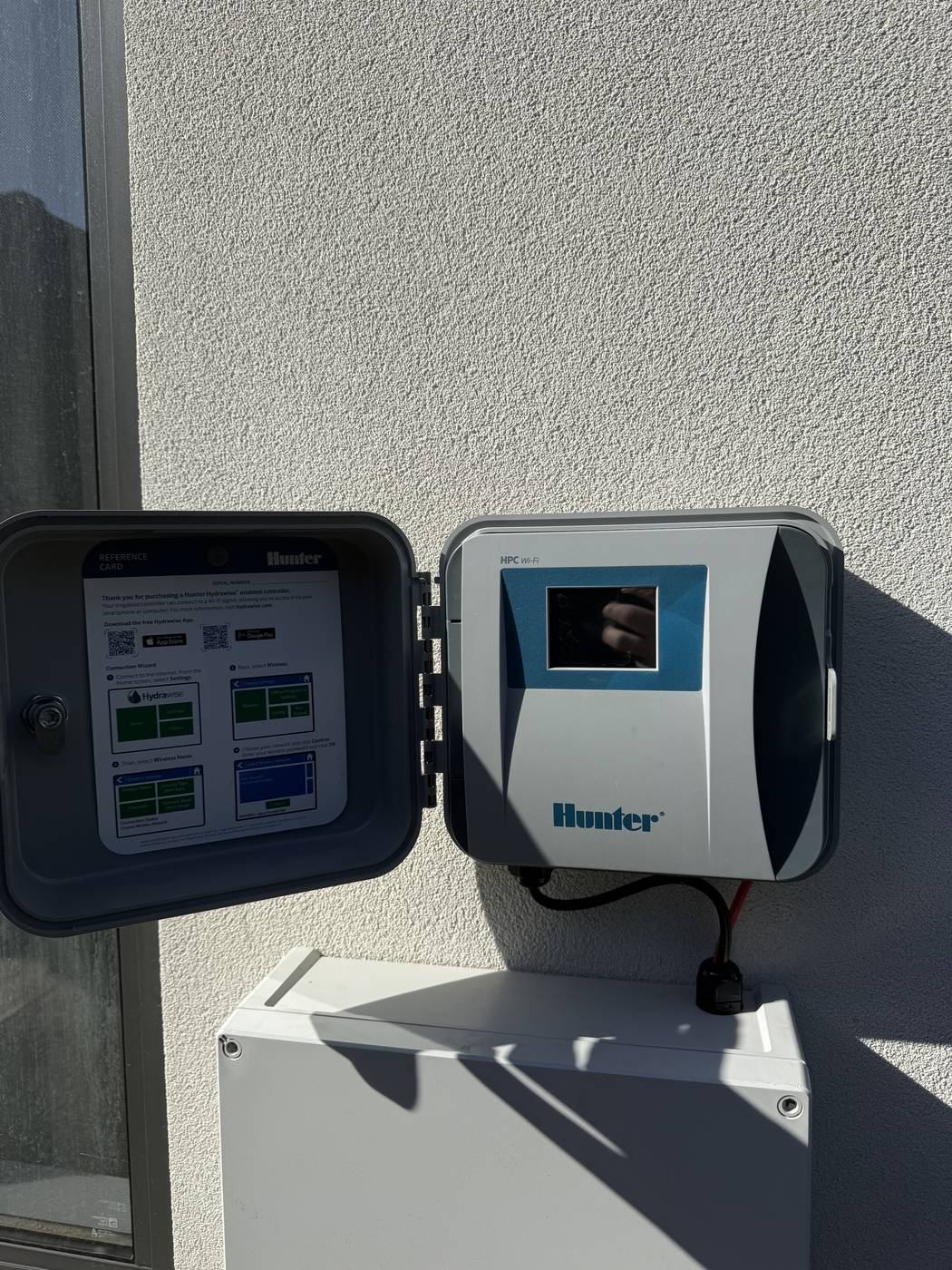 A Hunter wifi irrigation controller installed and programmed on a wall
